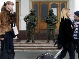Hombres armados, supuestos soldados rusos, custodian la entrada a un edificio cerca del aeropuerto de Simferópol, capital de Crimea. EFE /