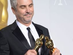 El director mexicano, Alfonso Cuarón, con los dos galardones obtenidos durante los Oscar de este año. AFP /