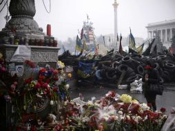 Una mujer se para frente a un muro de homenaje por las víctimas de los enfrentamientos en Kiev. AFP /