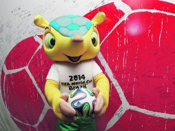 Con las manos ocupadas. Mientras que Fuleco, la mascota oficial, promueve el Mundial, los obreros concluyen las obras. AP /