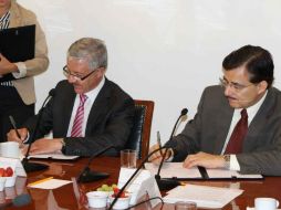 El titular de la SSJ, Jaime Agustín González (i), y el rector de la UdeG, Tonatiuh Bravo Padilla, firman el documento. ESPECIAL /