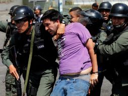 Guardias de seguridad arrestan a un manifestante opositor en medio de la nueva ola de protestas. AP /