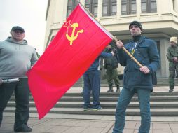 Un residente de Simferópol sostiene una bandera soviética frente a la Cámara legislativa de Crimea. AP /