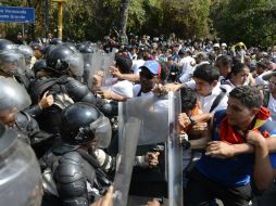 Estudiantes venezolano se enfrentan elementos de la seguridad pública en una manifestación en contra de Maduro. AFP /