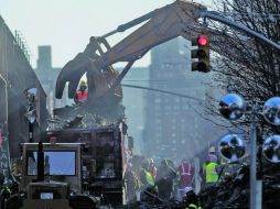 Bomberos trabajan en la zona del derrumbe en la remoción de escombro con la esperanza de encontrar a gente desaparecida. AFP /