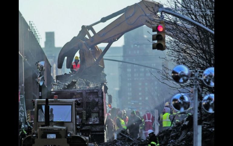 Bomberos trabajan en la zona del derrumbe en la remoción de escombro con la esperanza de encontrar a gente desaparecida. AFP /
