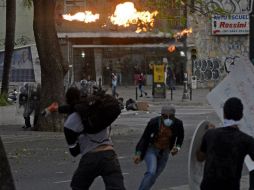 Manifestantes antigubernamentales lanzan bombas molotov a la policía durante una protesta. AFP /