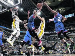 De poco sirve. Michael Carter-Williams (centro), de Filadelfia, baja un rebote ante la marcación de la defensiva de Indiana. AP /