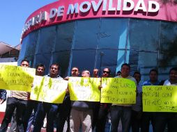 Los conductores muestran cartulinas en las que piden se les otorguen permisos para laborar en tanto cumplen con la capacitación.  /