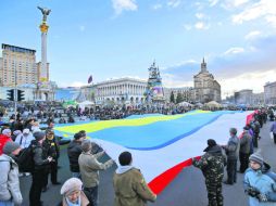Varias personas sujetan una bandera ucraniana unida a una de Crimea durante una protesta convocada en Kiev.  /