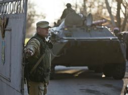 Un soldado prorruso abre una puerta para el ingreso de artillería a la base militar. AP /