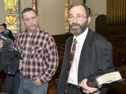 El pastor John Koletas (d) junto a Ron Stafford (i), ganador del rifle. AP /