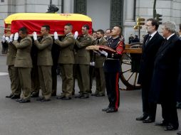 El féretro cubierto con la bandera española fue despedido con el himno nacional a su paso por la puerta de los Leones del Congreso. AFP /