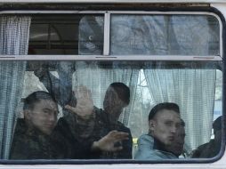Infantes de la Marina ucranianos en Crimea abordan autobuses para salir de la región y dirigirse a Ucrania. AP /