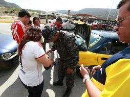 Elementos de la Fuerza Única revisan vehículos y pertenencias de los asistentes.  /