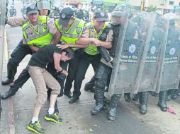 Desalojo. Policías someten a un manifestante en Plaza Altamira, en Caracas. AFP /