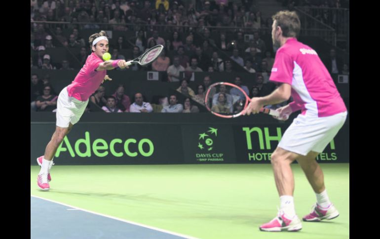 Roger Federer se estira para tratar de regresar una bola durante el juego de dobles. AFP /