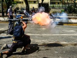 Uno de los manifestantes lanza un proyectil en contra de policías. AFP /