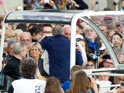 El Sumo Pontífice inivita a un amigo suyo, que reconoció entre la multitud a subir al papamóvil. EFE /