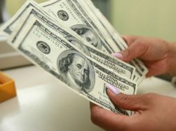 El tipo de cambio para solventar obligaciones en moneda extranjera pagaderas en el país es de 12.9642 pesos. ARCHIVO /