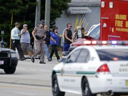 Un oficial escolta a familiares de las víctimas al lugar del accidente. AP /