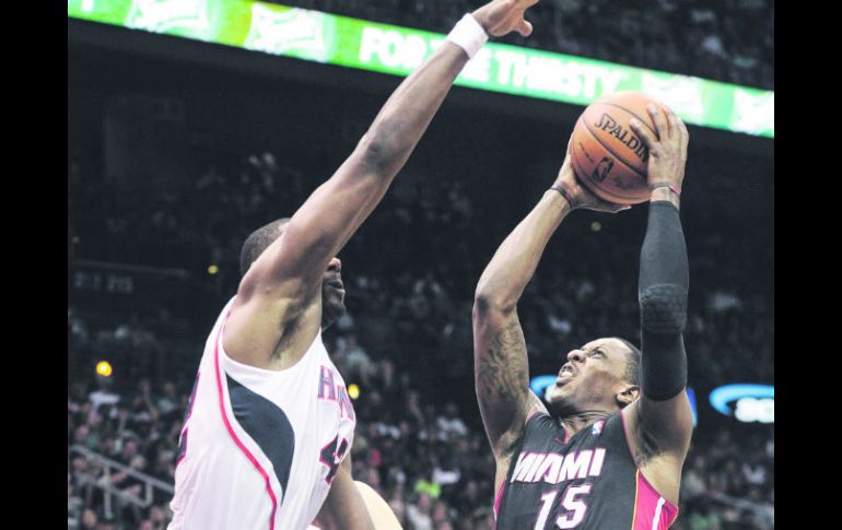 Mario Chalmers (15) del Heat de Miami trata de marcar ante Elton Brand de los Halcones de Atlanta, ayer en la Philips Arena. AP /