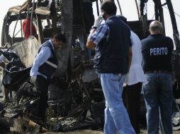 Peritos y personal forense realizan las investigaciones correspondientes en el autobús siniestrado. AFP /