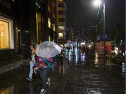 Capitalinos avanzan en medio de la lluvia. NTX /