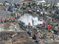 DESOLACIÓN. Voluntarios esperan órdenes de los encargados de coordinar los trabajos de limpieza en los cerros consumidos por el fuego. EFE /