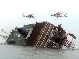 Dos helicópteros de rescate sobrevuelan el transbordador accidentado. AP /