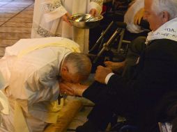 El Papa se arrodilla, lava, seca y besa los pies de doce personas, algunas en silla de ruedas, otras con pies hinchados y desfigurados. AFP /