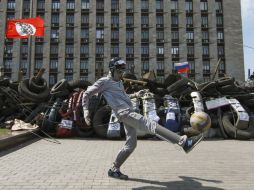 Un manifestante prorruso juega con un balón junto a un edificio de la administración regional ocupado por los manifestantes. EFE /