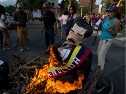Los manifestantes queman una figura con forma de Nicolás Maduro. AP /