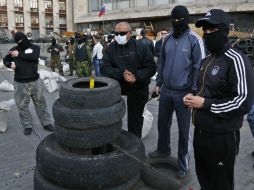 Prorrusos enmascarados continúan montando guardia en la barricada en el edificio de administración regional en Donetsk. AP /