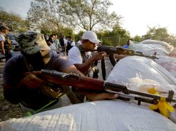 Las autodefensas se instalan en la región luego de retirar postes y árboles que bloqueaban el camino. ARCHIVO /