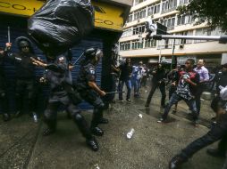 Manifestantes arrojan basura y piedras a elementos policiales en las favelas de Copacabana. EFE /