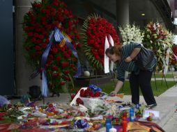 Una seguidora del Barcelona coloca un arreglo floral en el Camp Nou en memoria de Francesc ''Tito'' Vilanova. AP /