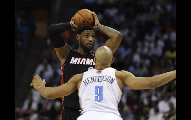 Lebron James (i) busca pasar el balón frente al jugador de Charlotte Bobcats Gerald Henderson (d), durante el partido. EFE /