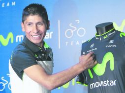 Nairo Quintana, firma una camisa del equipo de Movistar durante una rueda de prensa antes de viajar a competir en el Giro.  /