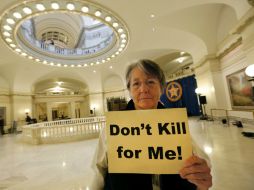 Margaret Cox, de la Coalición contra la Pena de Muerte, sostiene un letrero que en español dice 'No mates por mí'. AP /