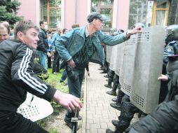 Policías ucranianos (derecha) intentan repeler el ataque de los prorrusos a la Fiscalía de la ciudad de Donetsk. EFE /