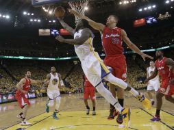 Draymond Green busca encestar bajo la marca de Blake Griffin, durante la primera mitad del juego. AP /