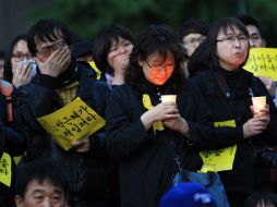 Personas rinden tributo a las víctimas del naufragio del ferry surcoreano, que suman 230 muertos y 72 siguen desaparecidos. AP /