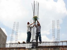 Los trabajadores fabrican una cruz con materiales de la obra y la colocan en la parte más alta de la construcción. ARCHIVO /