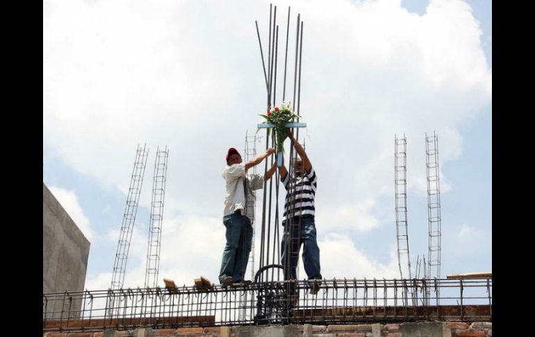 Los trabajadores fabrican una cruz con materiales de la obra y la colocan en la parte más alta de la construcción. ARCHIVO /