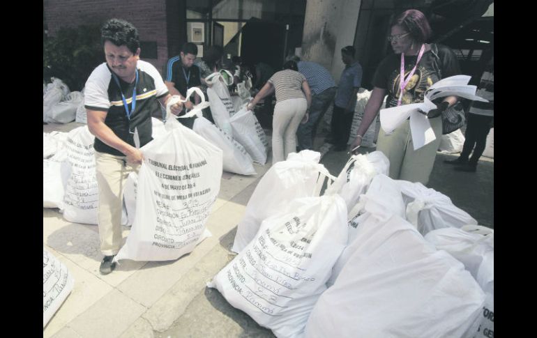 Trabajadores electorales organizan las bolsas con el material de votación. AP /