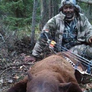 Circula foto de Karl Malone junto a un oso muerto