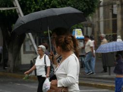 Los tapatíos vuelven a utilizar sus paraguas ante la incipiente lluvia que se registra en Guadalajara.  /