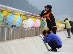 Familiares de las víctimas del accidente lloran en el puerto Jindo. AP /