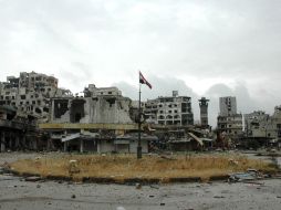 Las autoridades del régimen de Damasco izan la bandera de Siria en el casco antiguo de la ciudad de Homs. AFP /